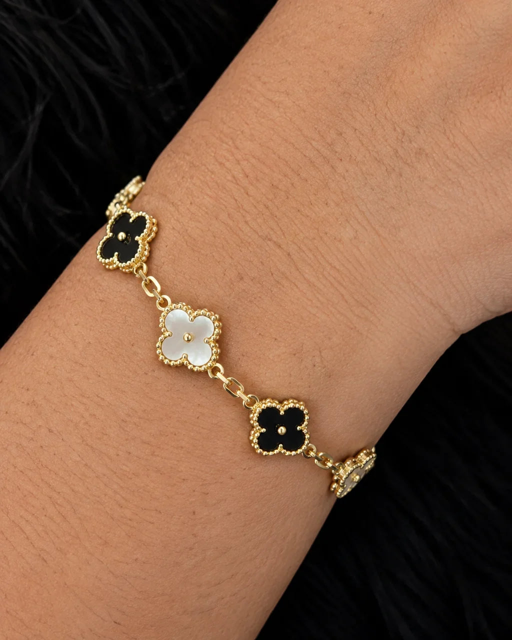 Bracelet à trèfles contrastés porté au poignet en gros plan